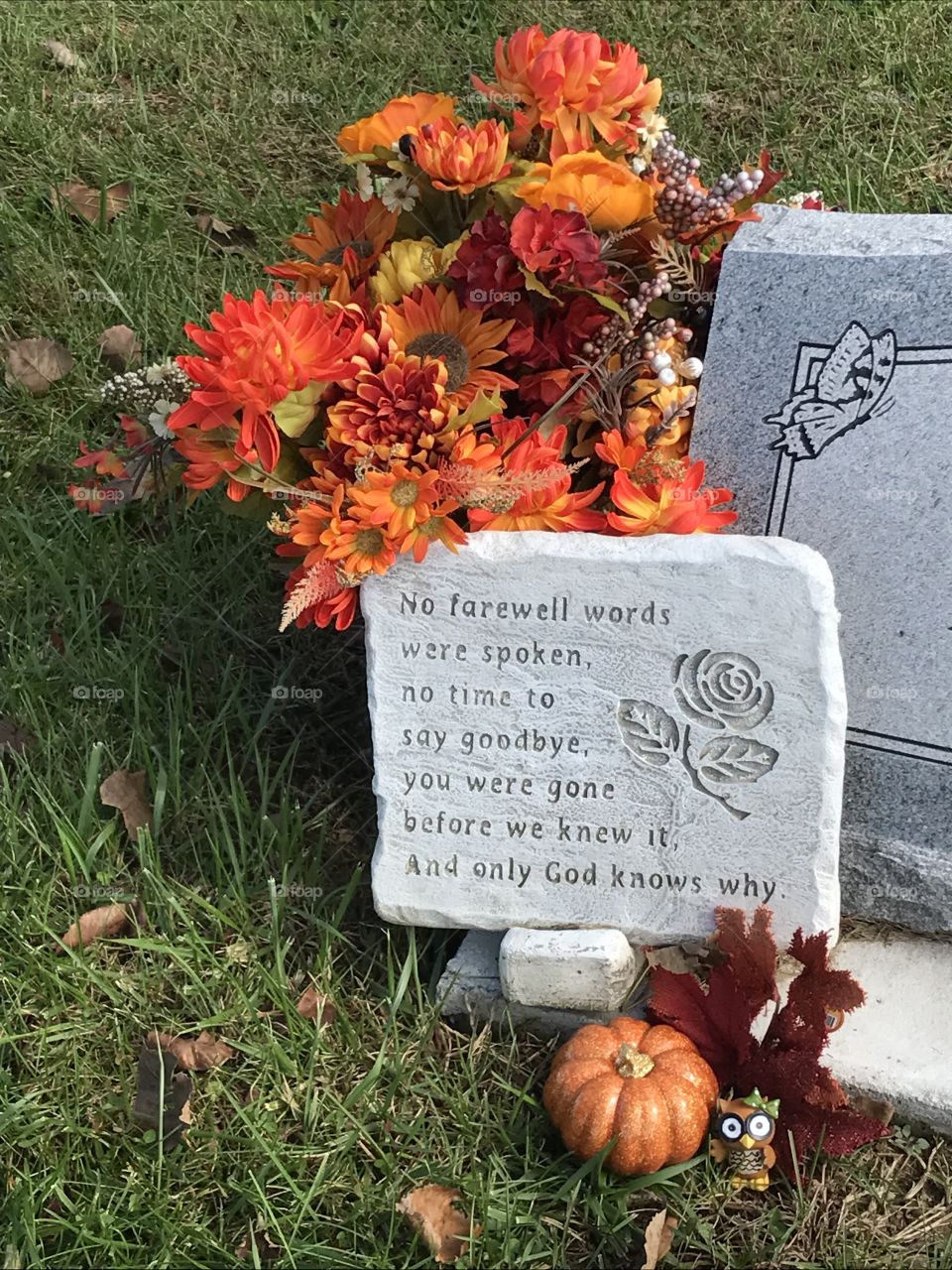 A headstone at a cemetery has been recently visited and decorated for the autumn season.