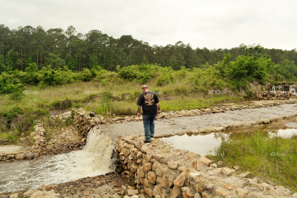 My husband walking on the rocks near a spring in a Texas state park