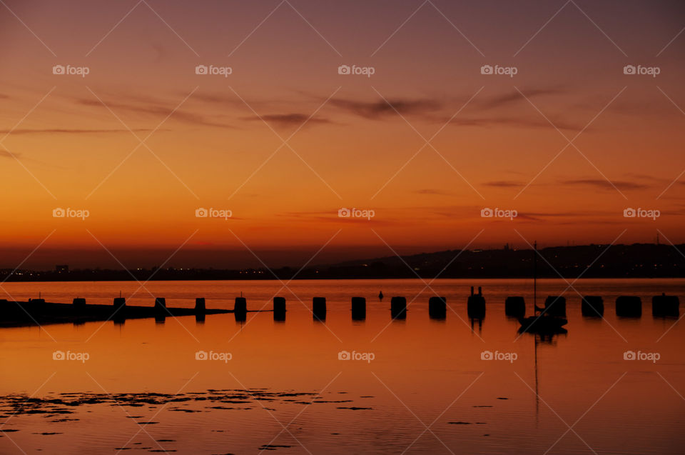 Sunset silhouette photo. Orange sky. Reflections. 