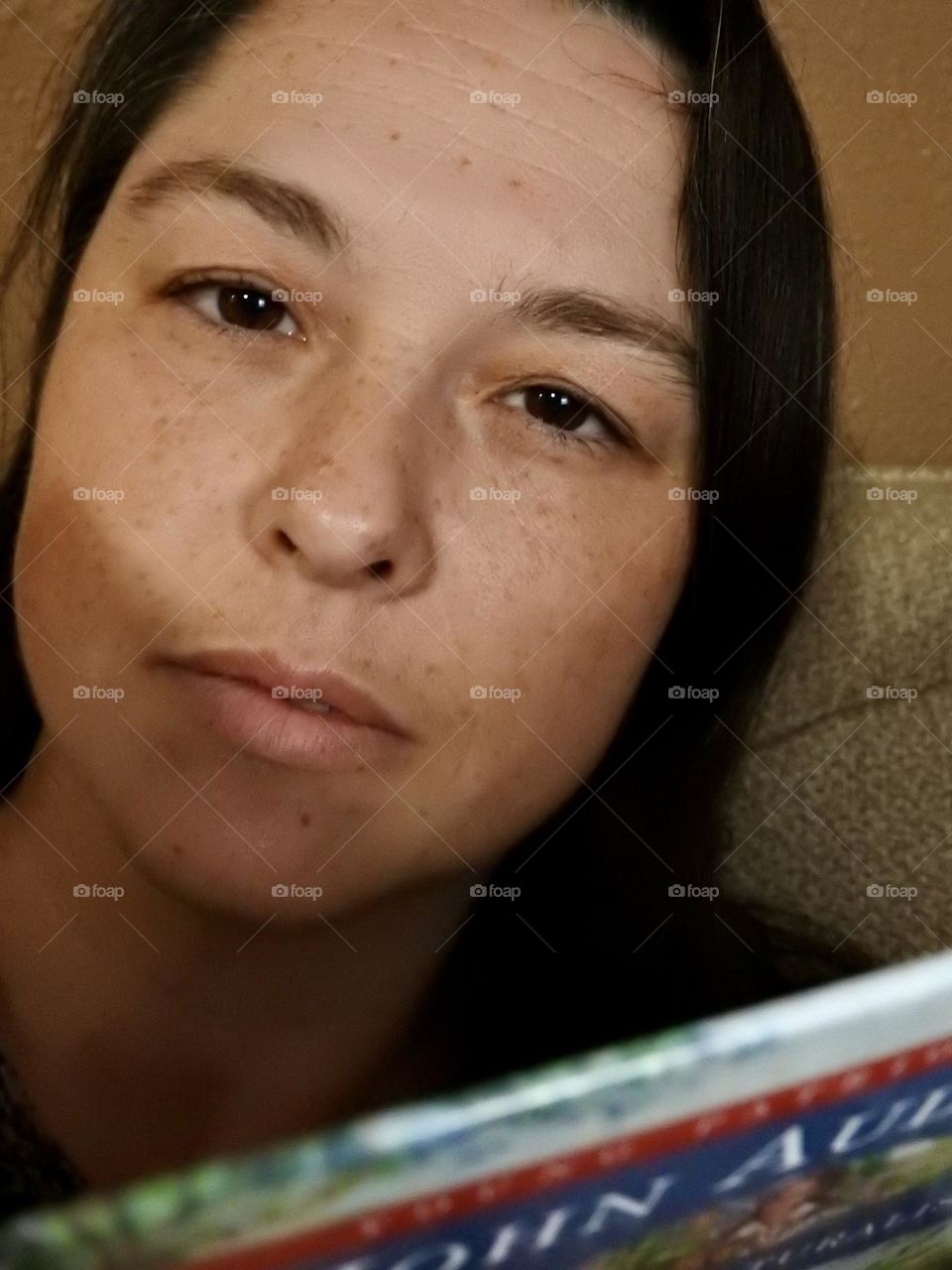 Face skin in the forties of a woman with freckles and brown hair.