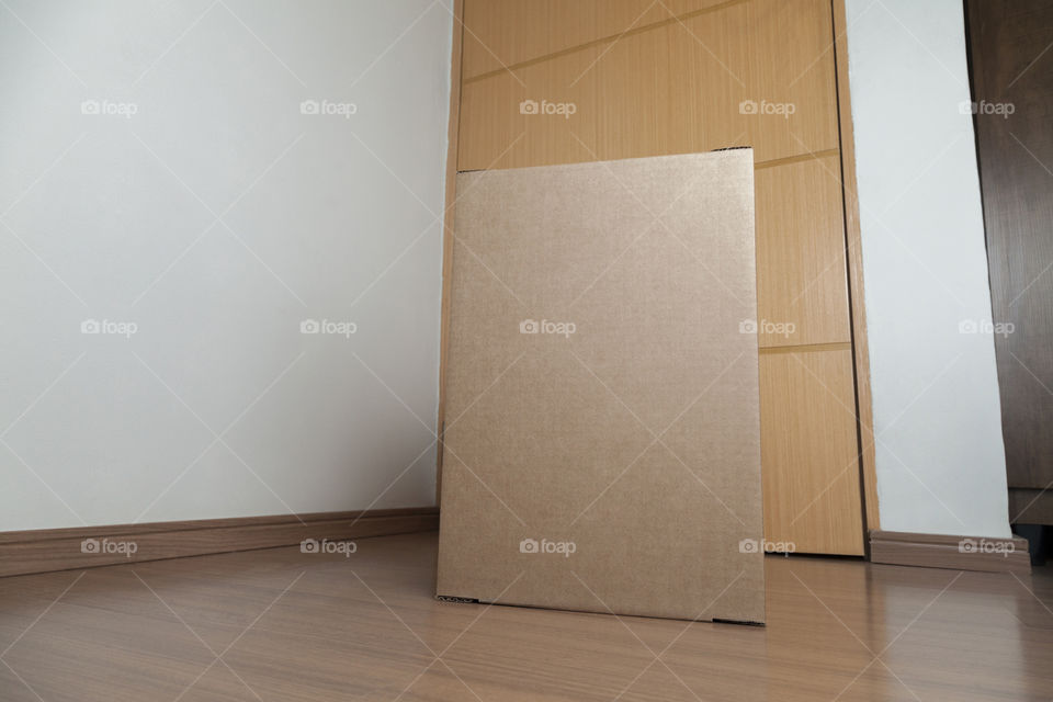 Cardboard box with order placed on the floor in an empty room with a neutral background. delivery concept. economy concept. business concept. shopping concept. copy space. Nobody