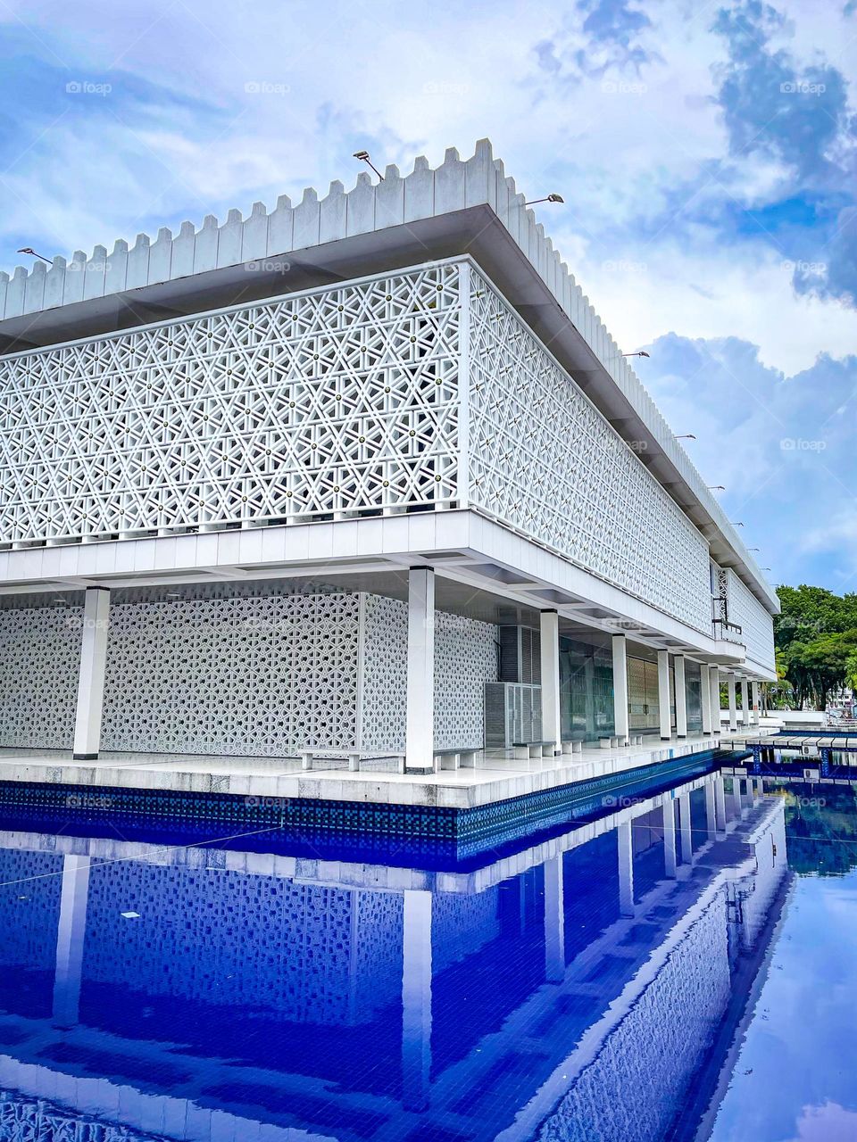 Mosque architecture view from outside with blue pond on the side