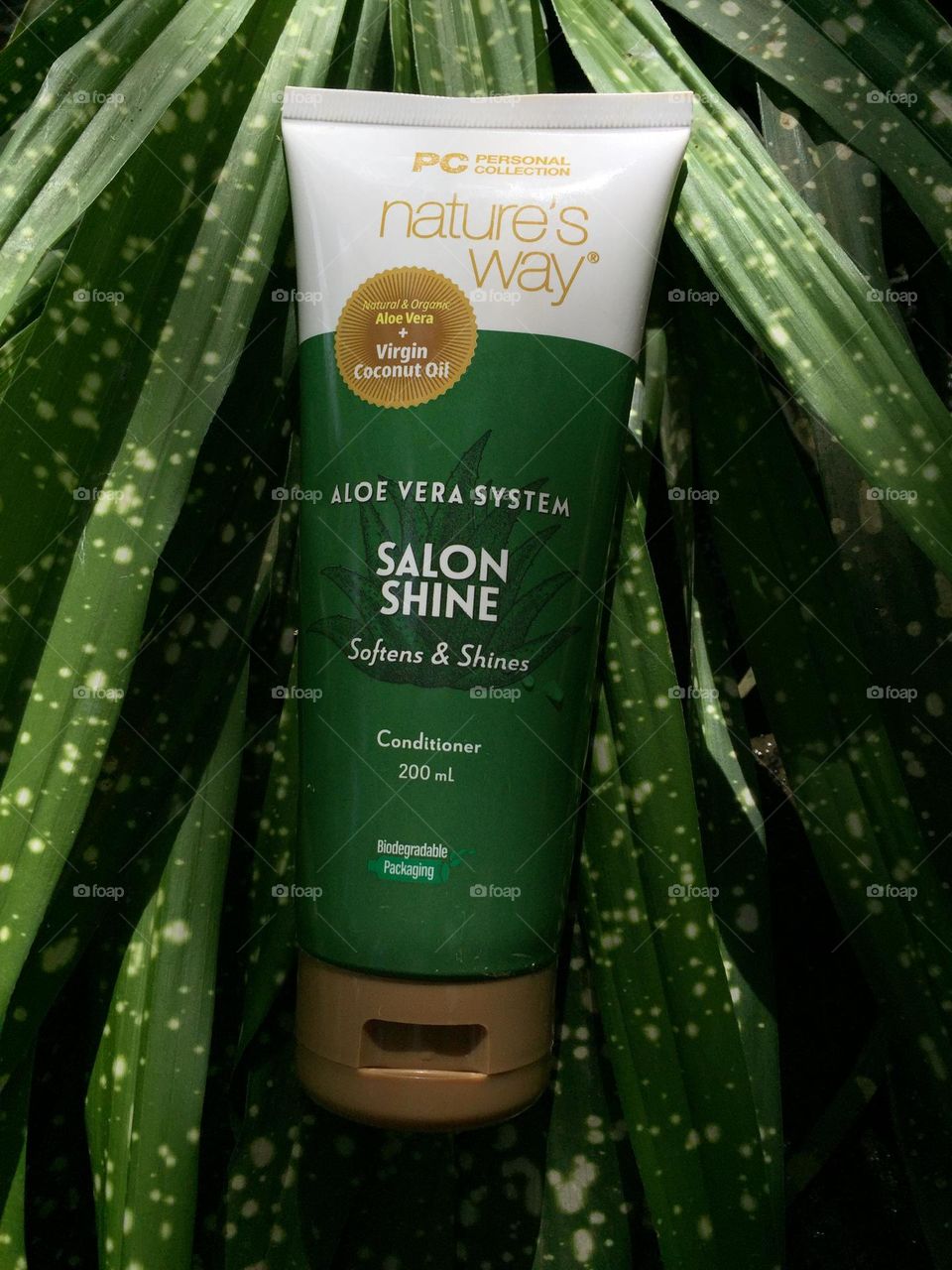 Hair conditioner with dotted green plants on the background 