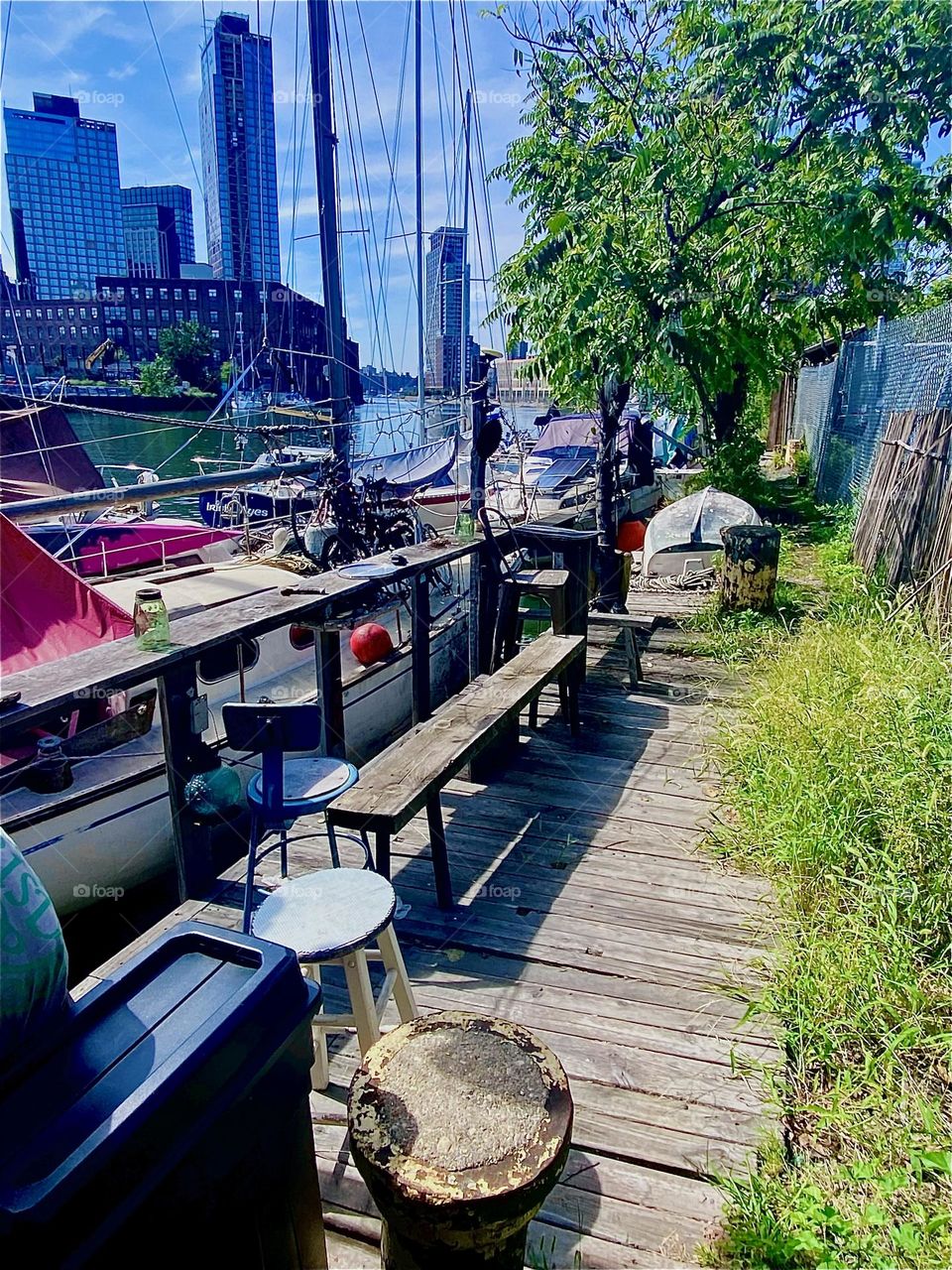 This is the sailboat with the three bicycles next to the wooden veranda at “Newtown Creek” by the “Pulaski Bridge” on a pleasantly warm but not hot Indian summer afternoon when the outdoors is a more inviting place to be, 2023. Hypnotic Productions