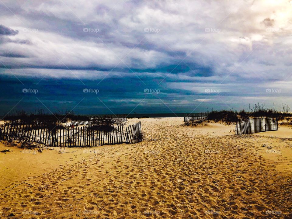 Storm clouds rolling in at the beach over sand
