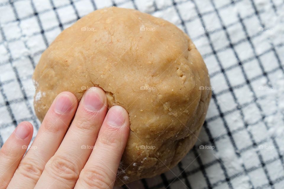 Fingers knead dough for homemade bread