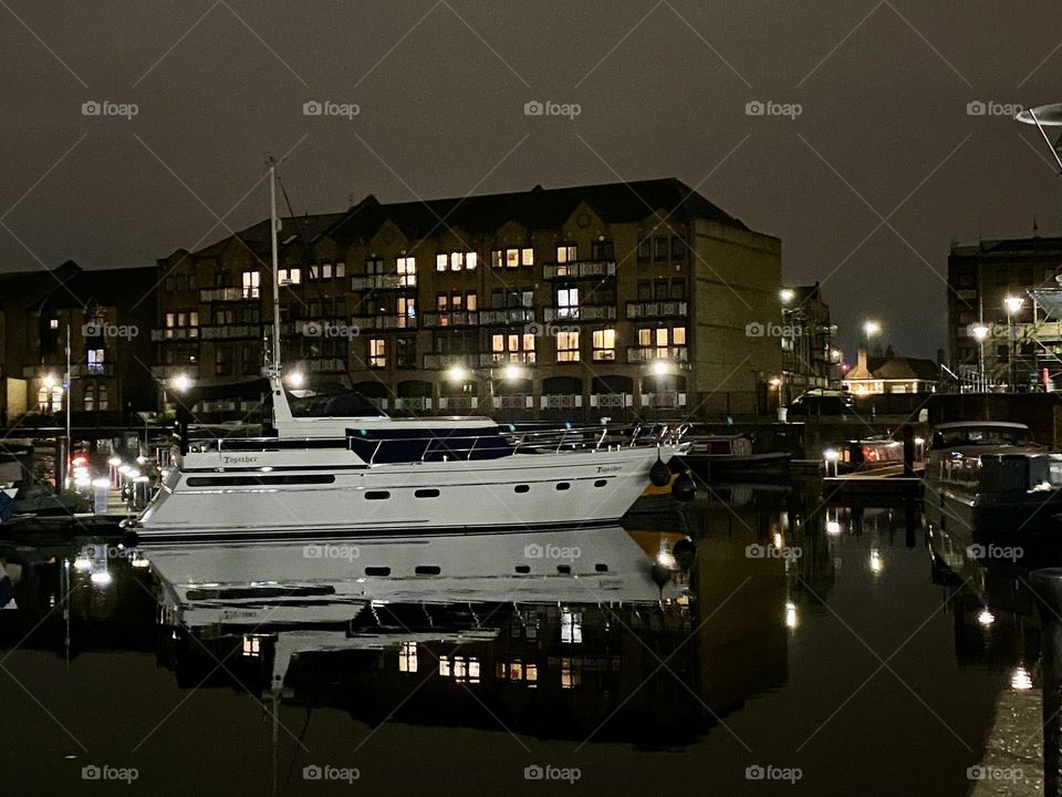 Buildings with illuminated windows during evening and reflection at water