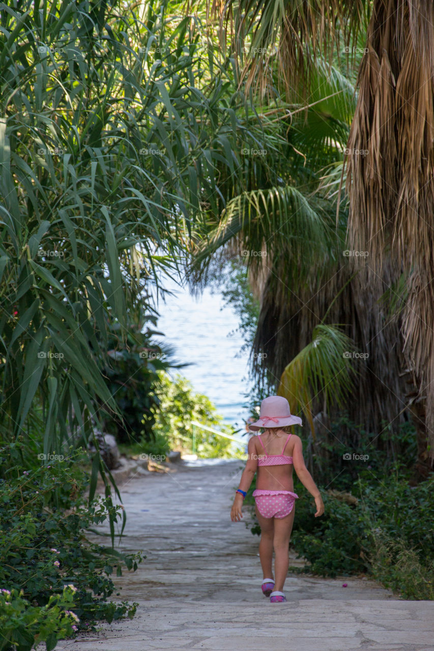 Little girl 4 years old on holiday walking to the beach in Cyprus.
