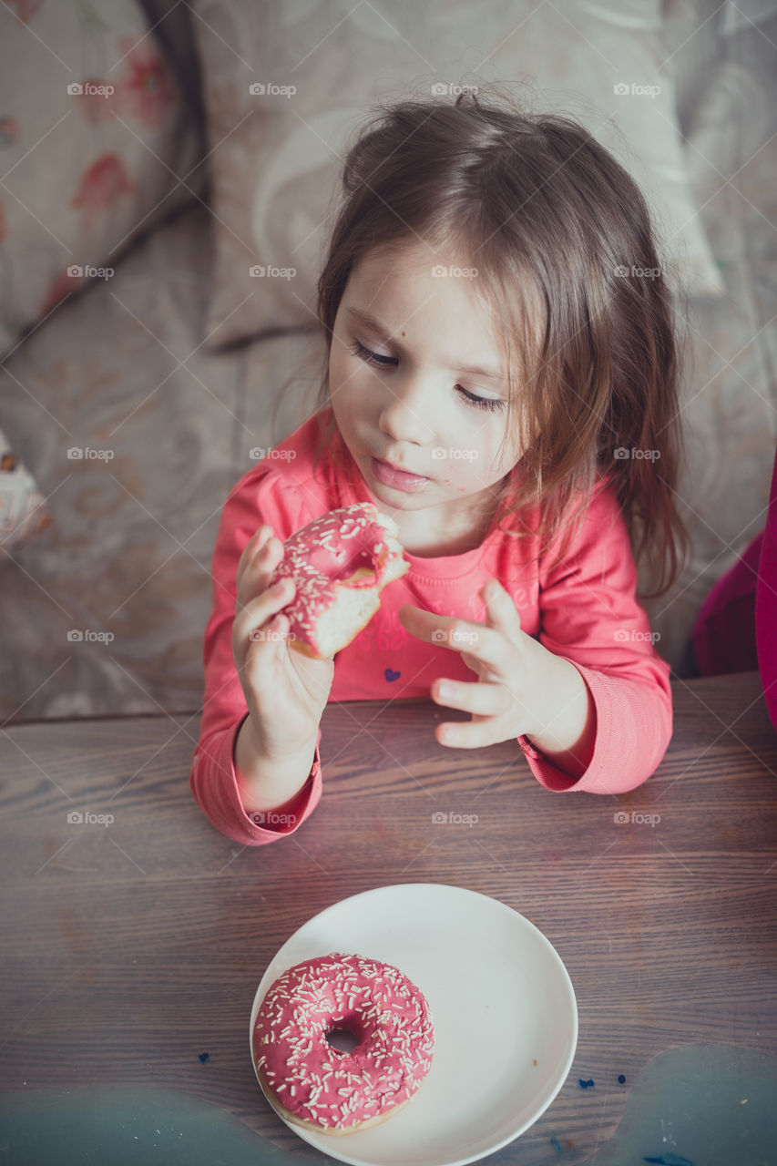 Little girl eating donuts 