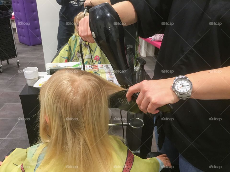 Little girl at the hairdresser at a local saloon in Malmö Sweden.