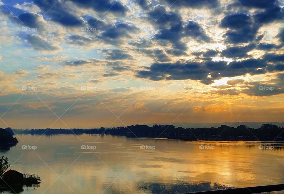 The view from the bridge to the river and the dramatic sunrise.  Springtime