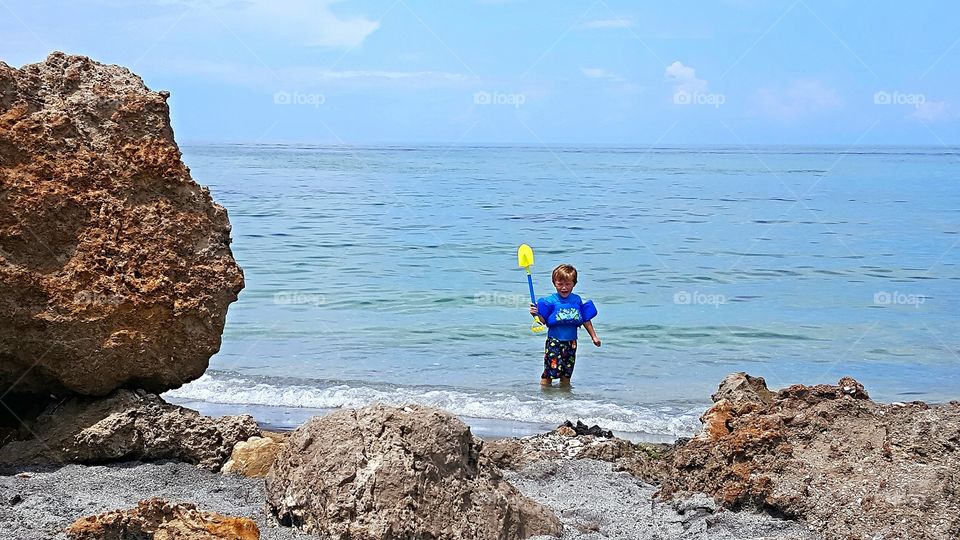 lovely boy Ayden digging up seashells at Venice beach Fl.