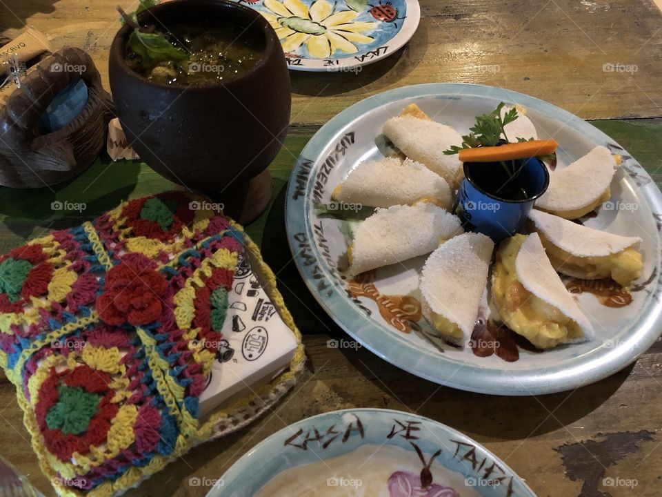 Dish of small tapiocas filled with shrimp and a cup of caipirinha