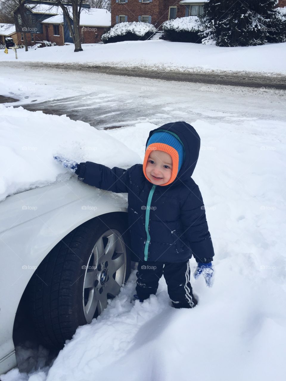 Cute boy standing near the white car