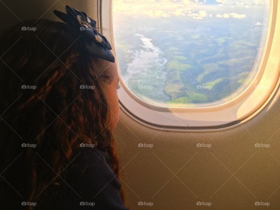 Little girl looking at the view inside the airplane