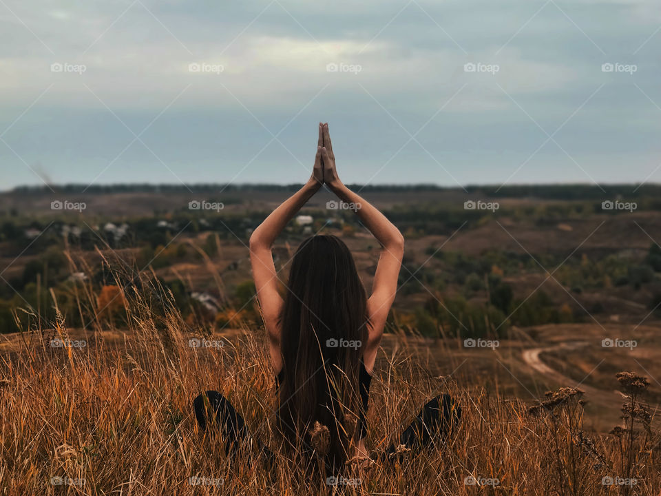 Young woman with long hair doing yoga outdoor 
