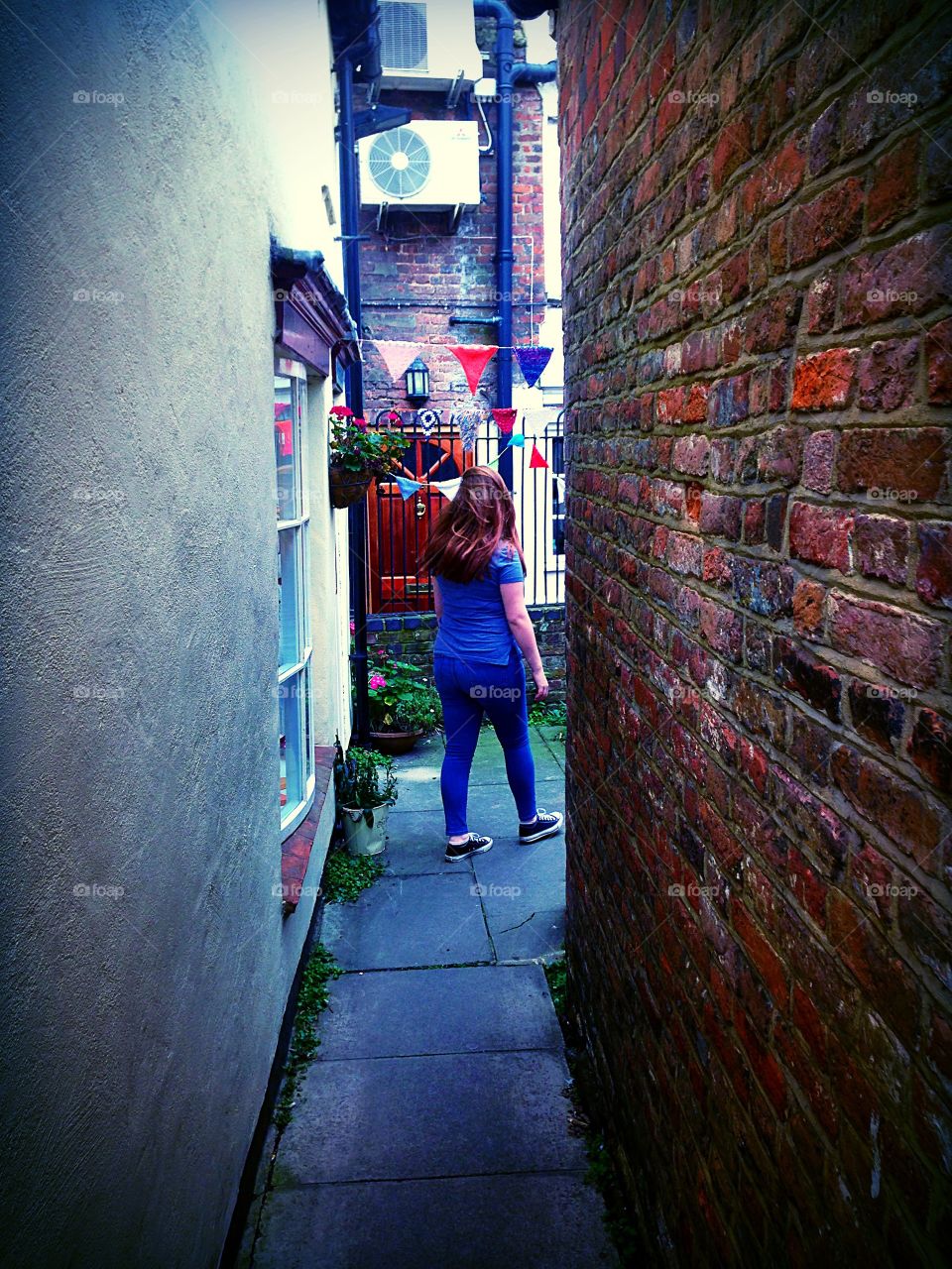 Rear view of a girl walking down an alley 