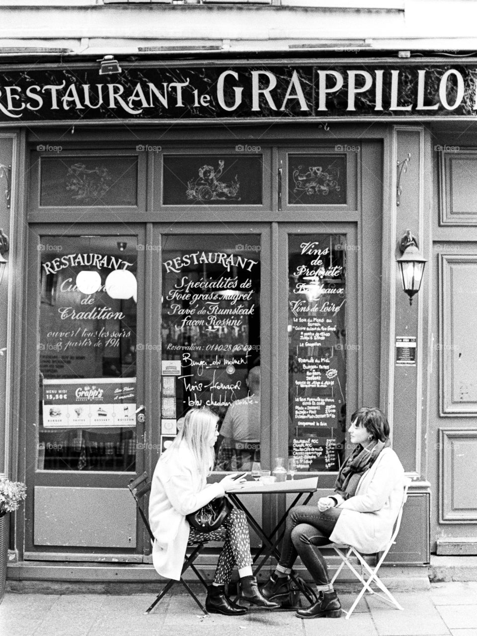 Two girls dining outside a Paris restaurant 