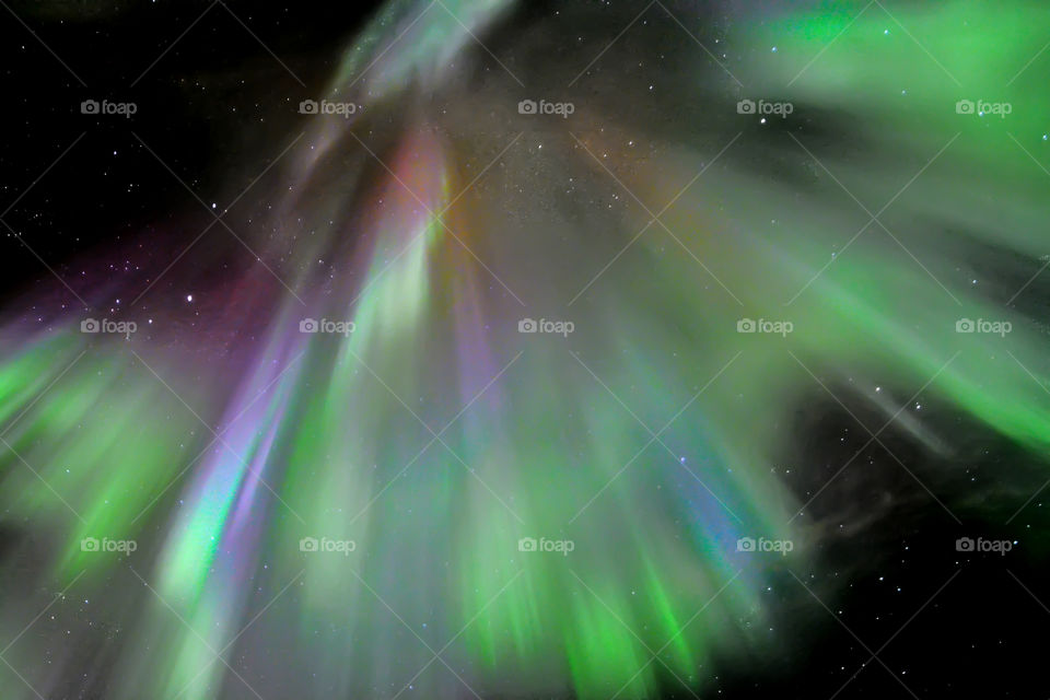 Aurora Borealis across dark starry night during winter in Iceland