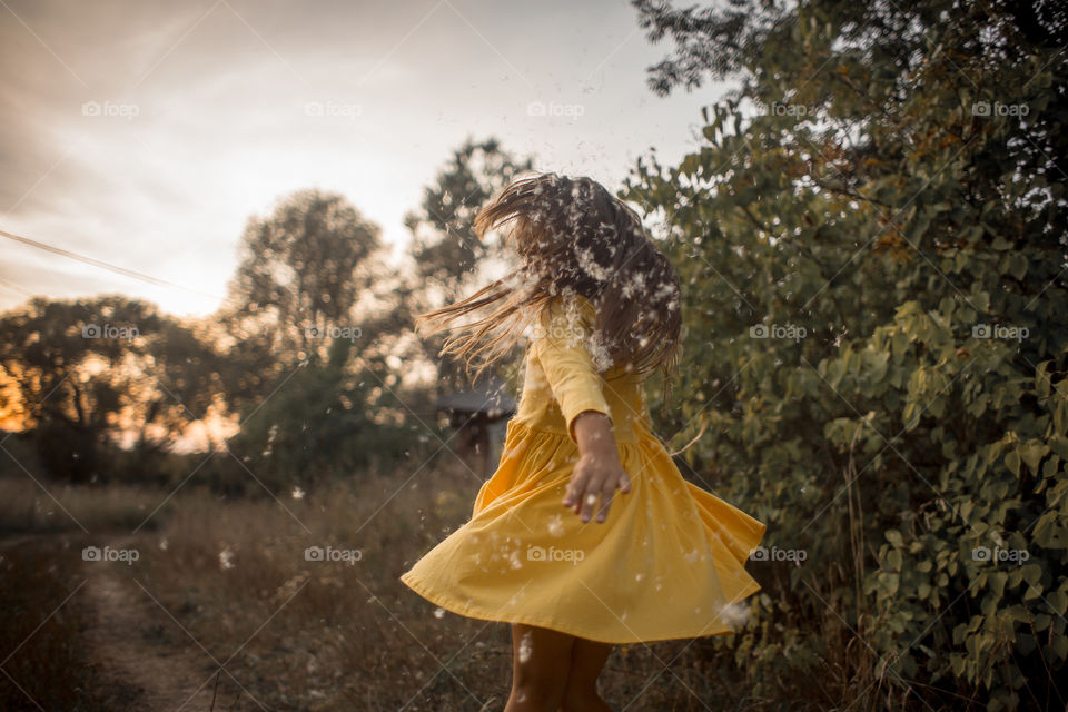 Little girl in yellow dress outdoor portrait at sunset 