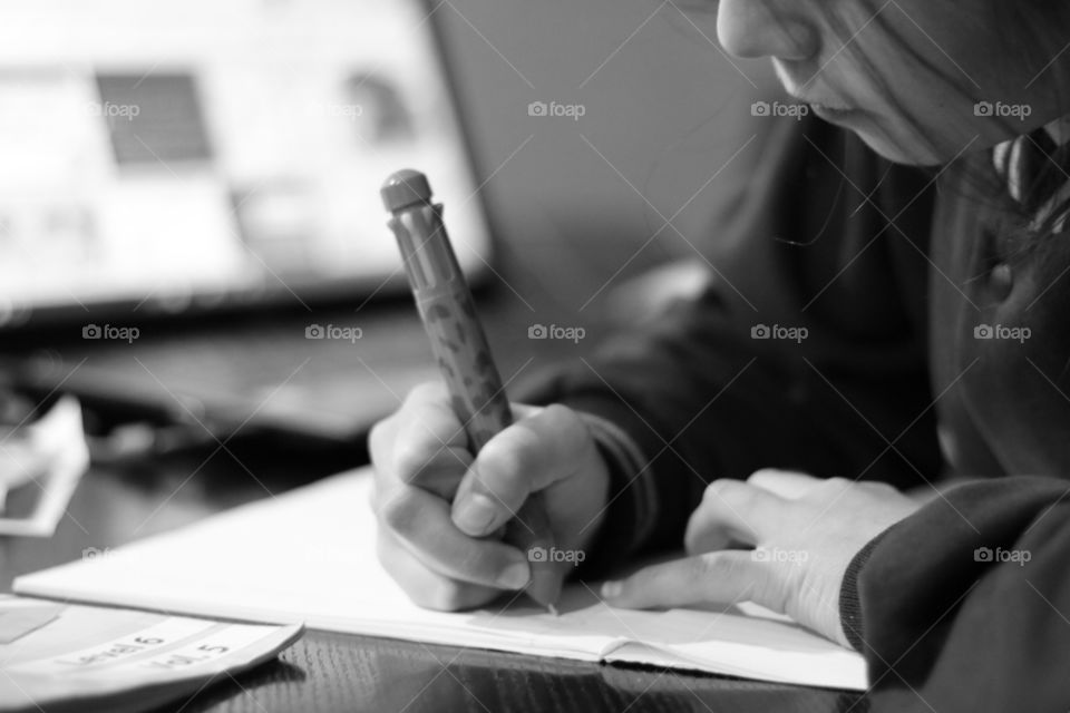 Small girl writing on book