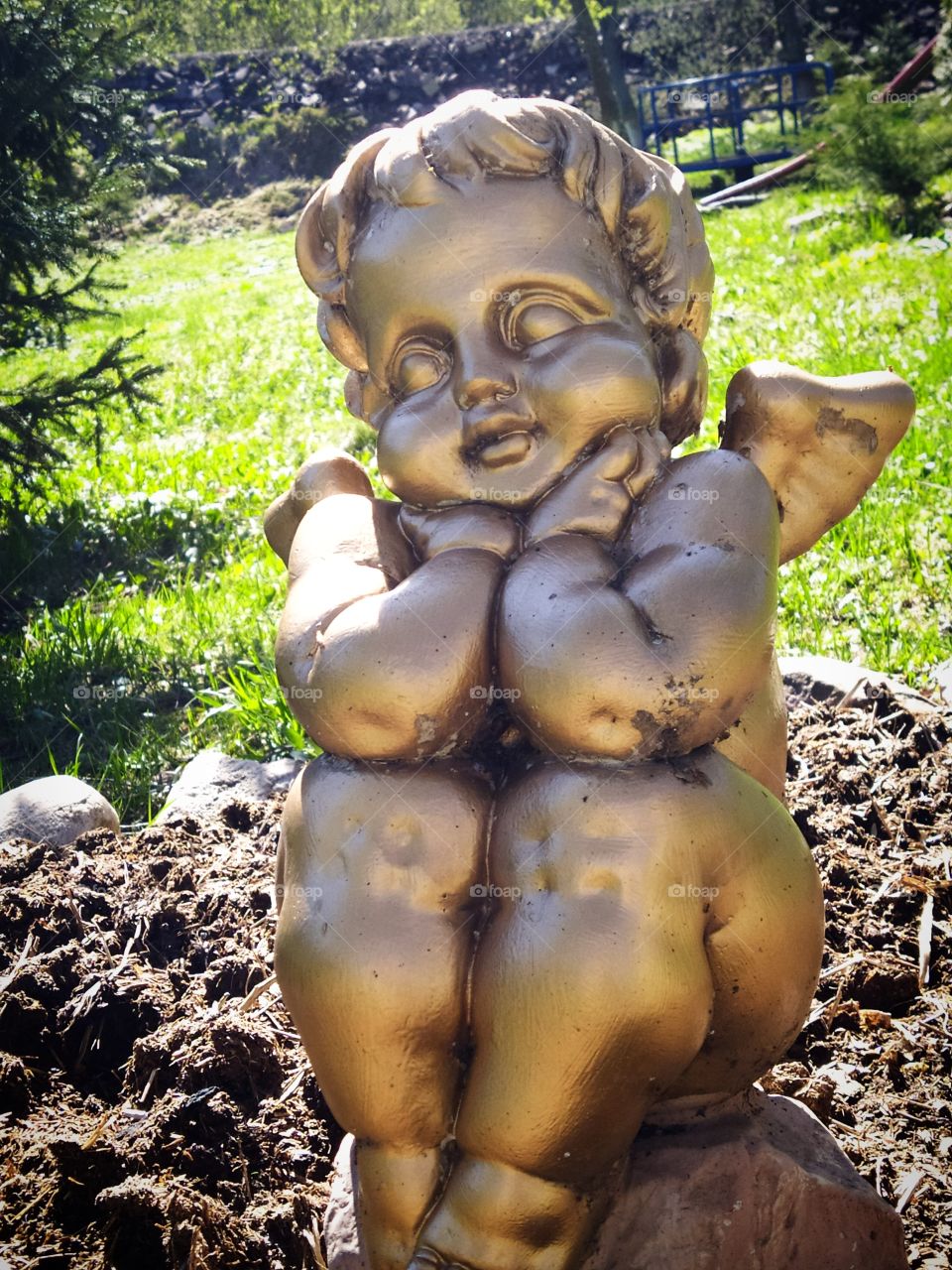 Sculpture of a little angel on a background of green grass