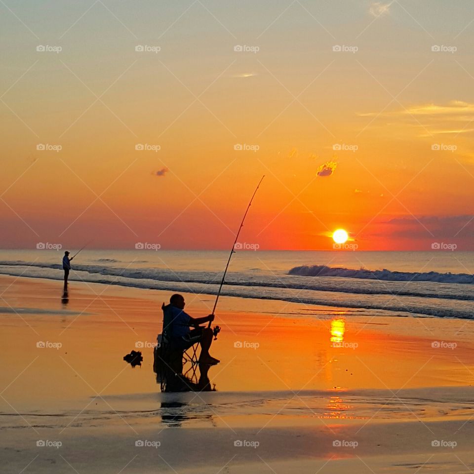 fishing on the beach at sunrise