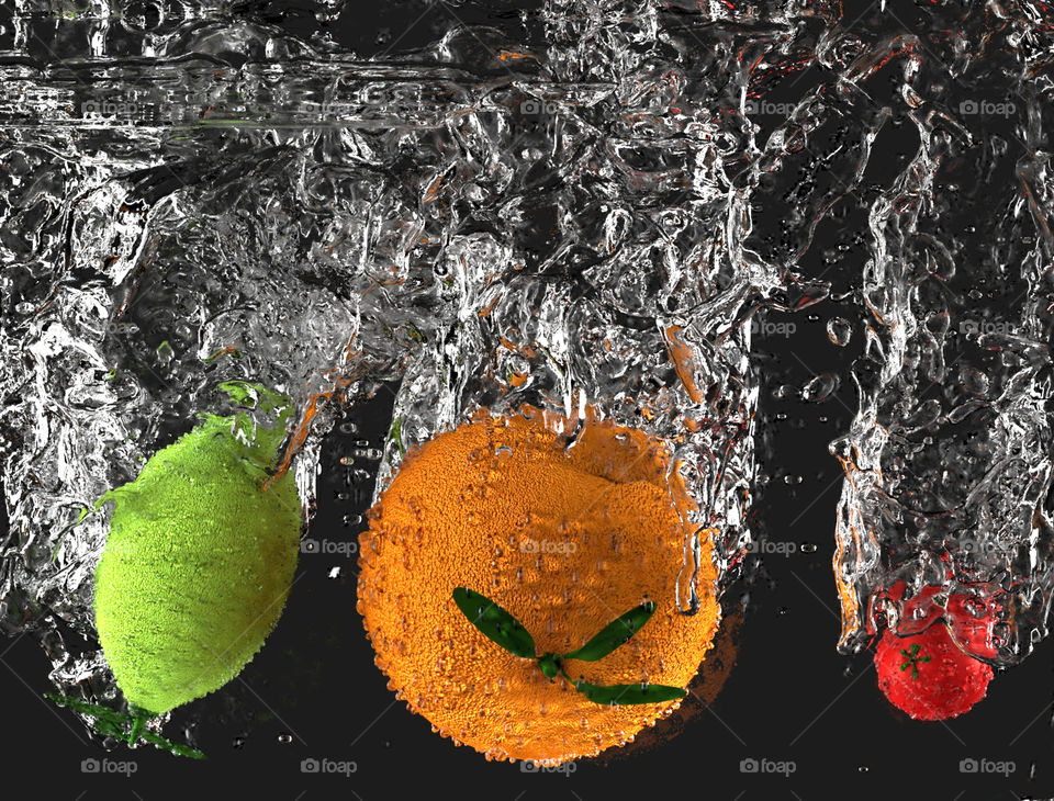 Rendered 3D Image { A lemon, an orange & a tomato dropped into water }
