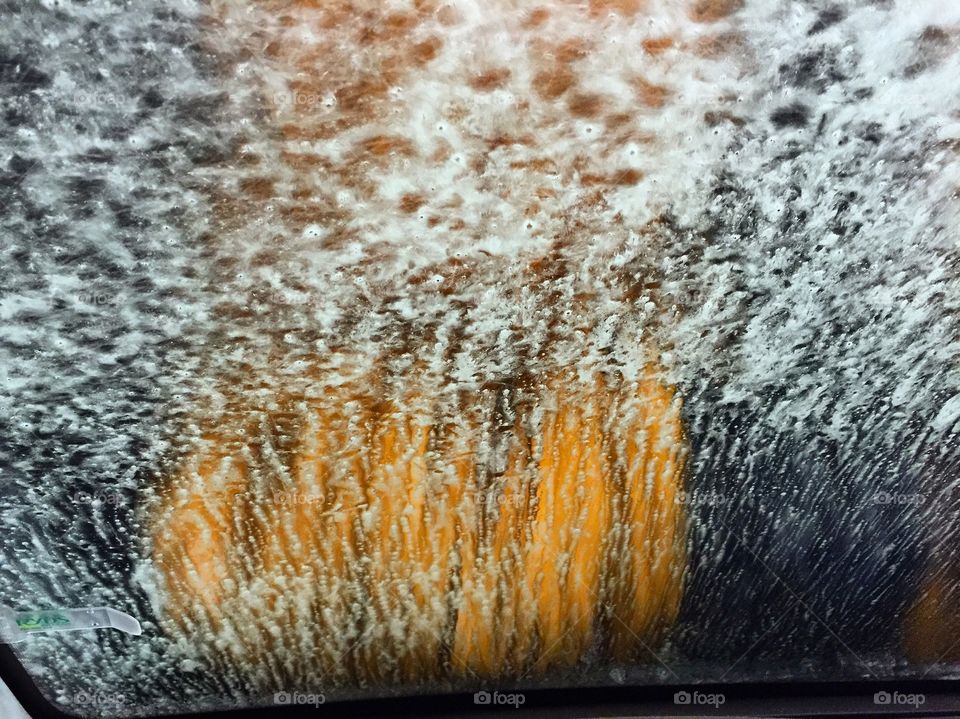 Close-up of soap suds on car window