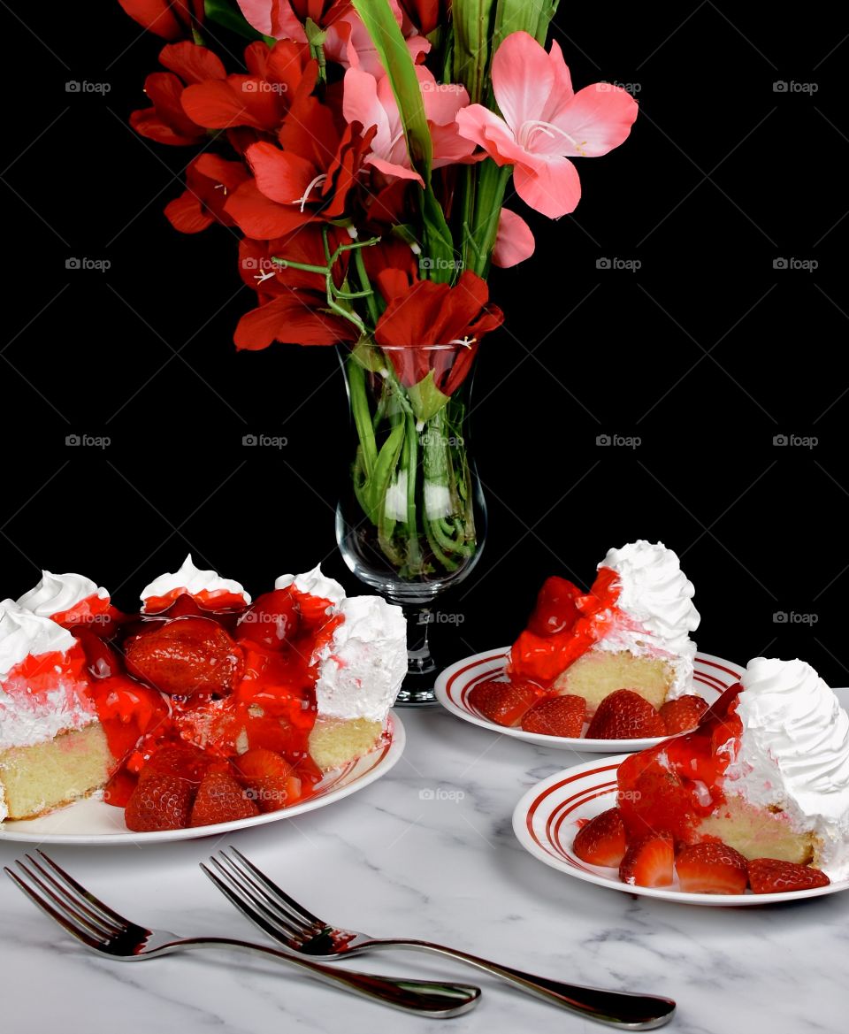 Delicious white cake with whipped cream frosting and strawberries on top 