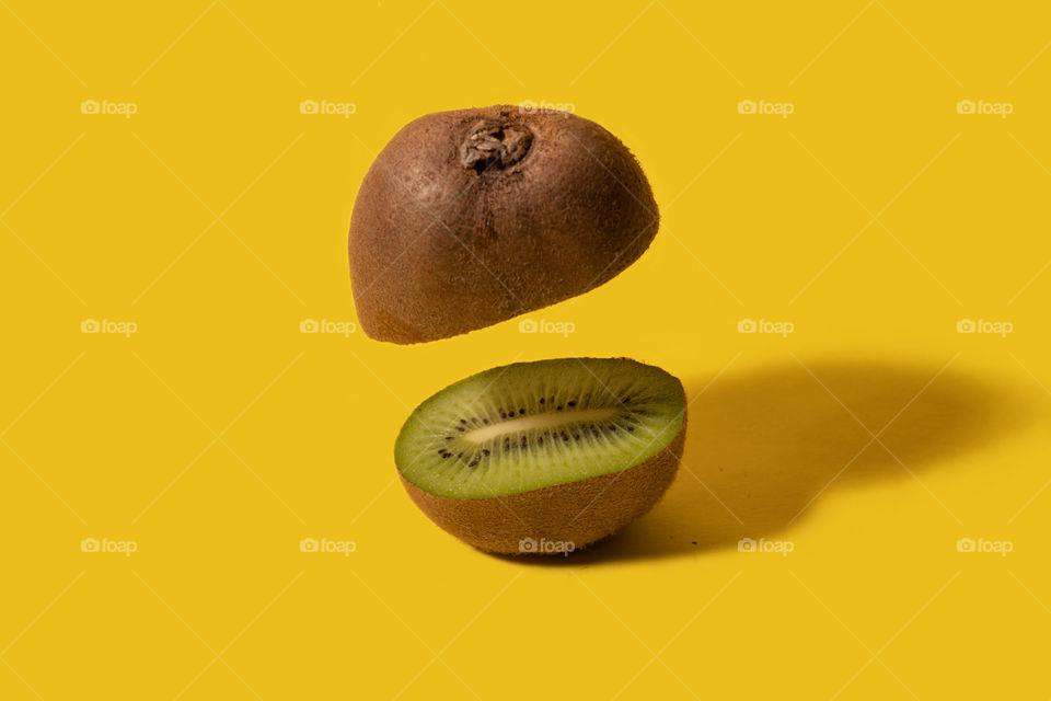 Kiwi sliced on half with one half floating