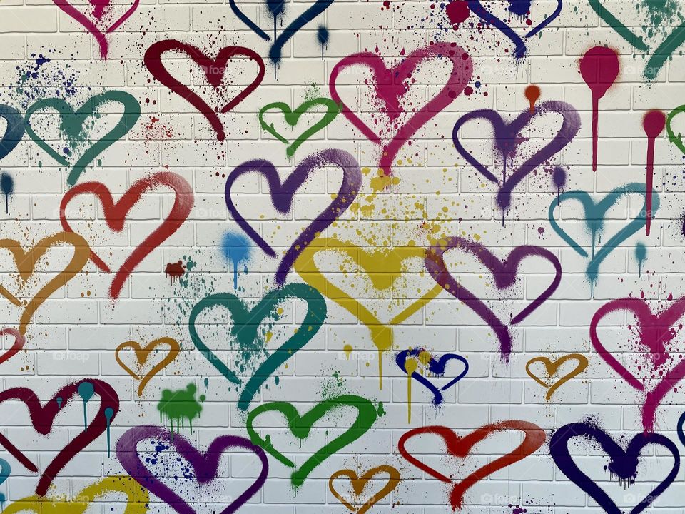 Hearts painted on a wall in a rainbow of colors