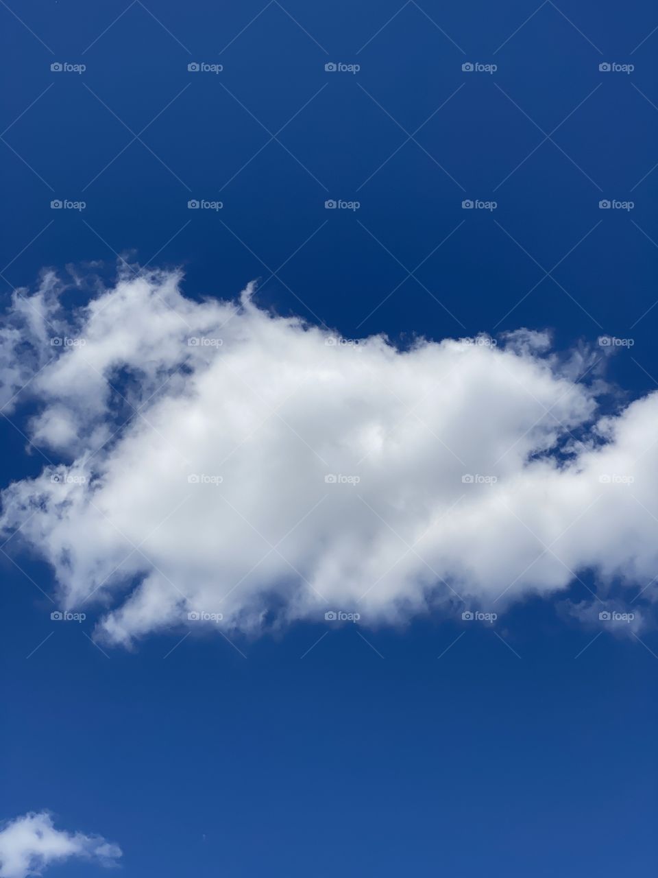 Single clouds hanging and moving in the blue sky. Natural beauty of creation. Sky blue.