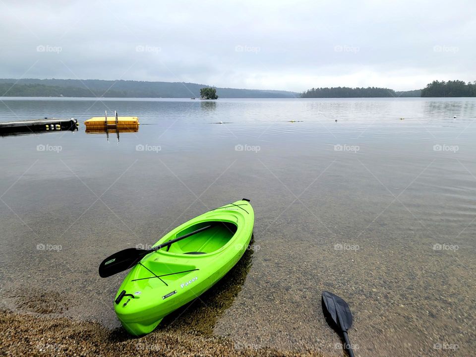Green Kayak Sitting on Lake Shore