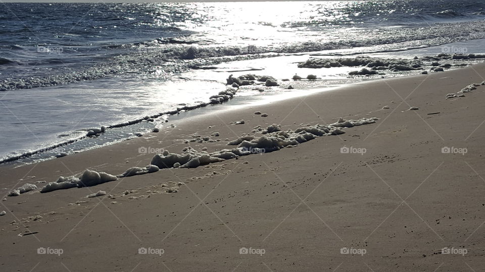foaming surf follows a winter storm at the beach.