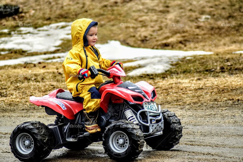 boy fourwheeling in the rain