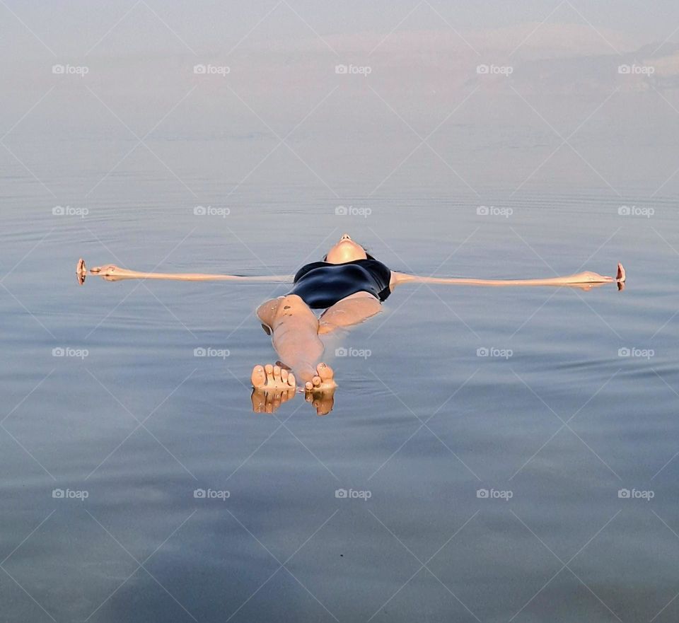 beautiful woman floating on her back in the dead sea
