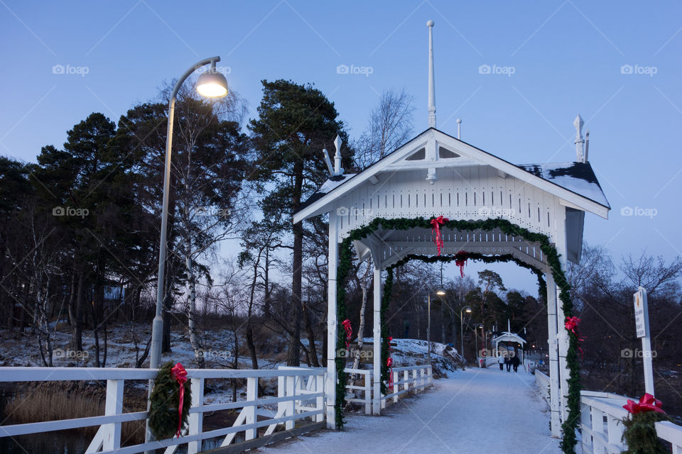 HELSINKI, FINLAND - DECEMBER 27: Old and historical wooden bridge from Seurasaari outdoors museum island towards mainland Helsinki decorated for Christmas decoration on cold evening December 27, 2015 in Helsinki, Finland.