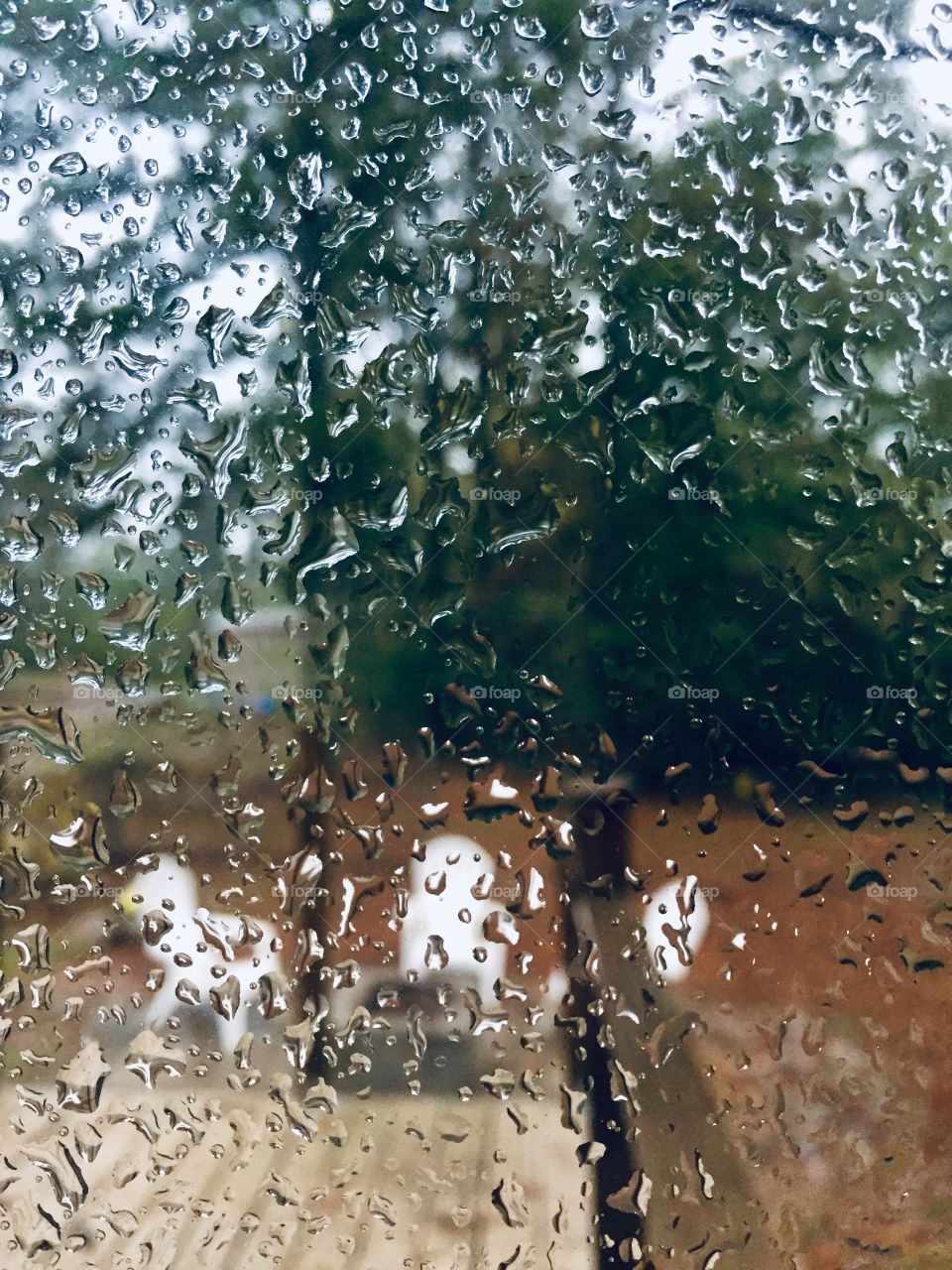 Rainy day. Raindrops on window glass. Blurred color of green and brown nature. Come again another day