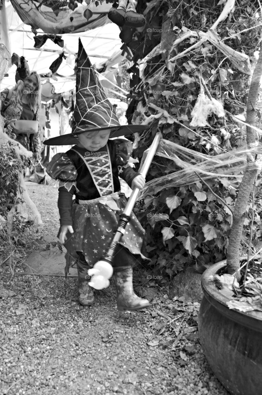 little girl dressed as a witch . black and white image.