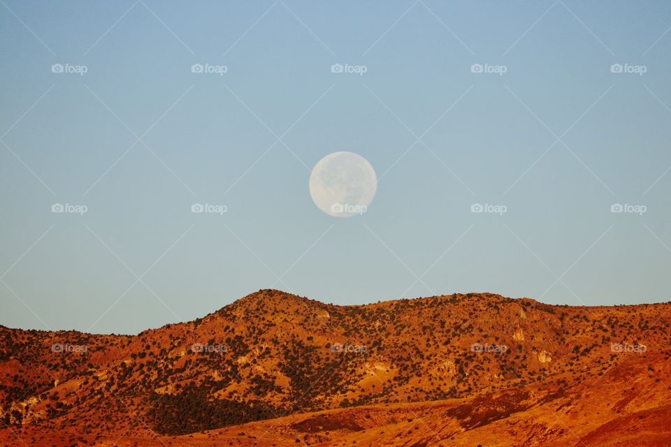 Early morning moon over the Sierra Nevada high desert mountains 