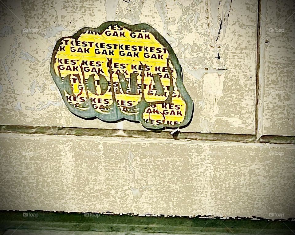 Incomprehensible word parts are shown in this collaged piece of “Graphic Design” behind the word “COMA” inside a balled fist ready to go for a knockout by rendering the opponent unconscious, hopefully not by inducing a coma.2022. Hypnotic Productions