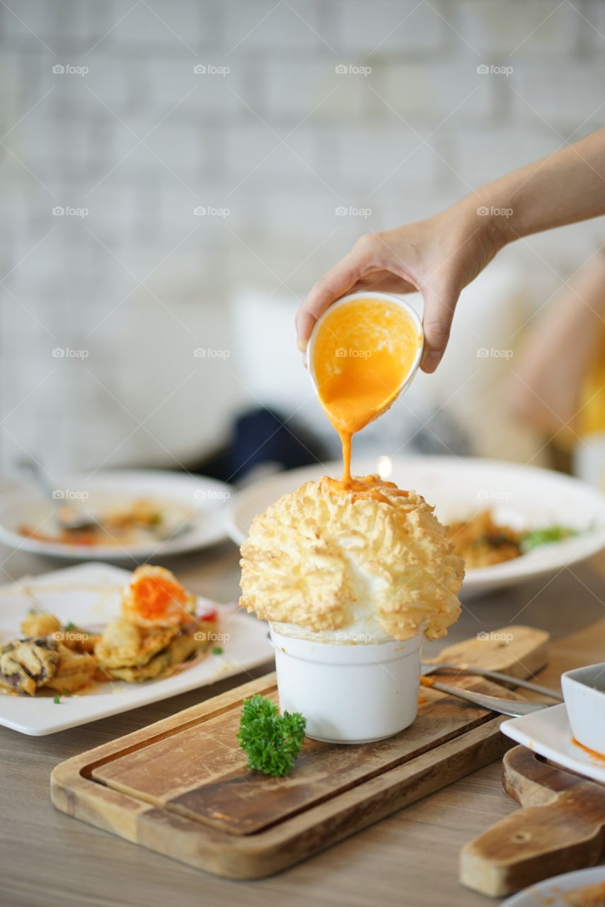 Souffle. A hand pouring down a salty eggs for the crab souffle .