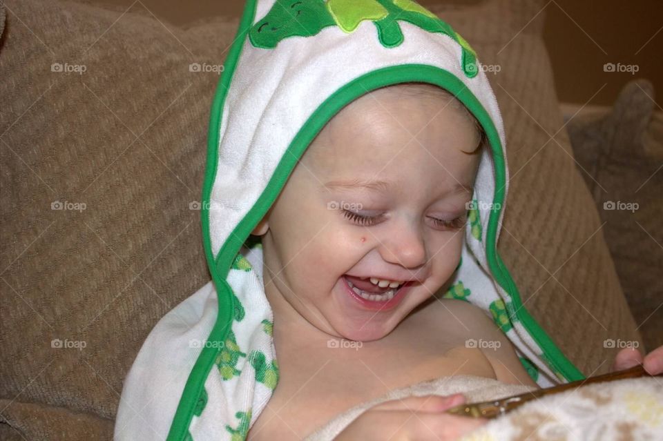 A toddler boy laughing at videos on the iPhone. 