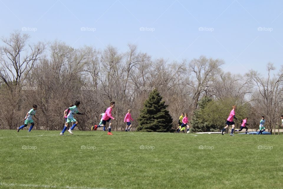 Kids playing soccer in a beautiful spring day 