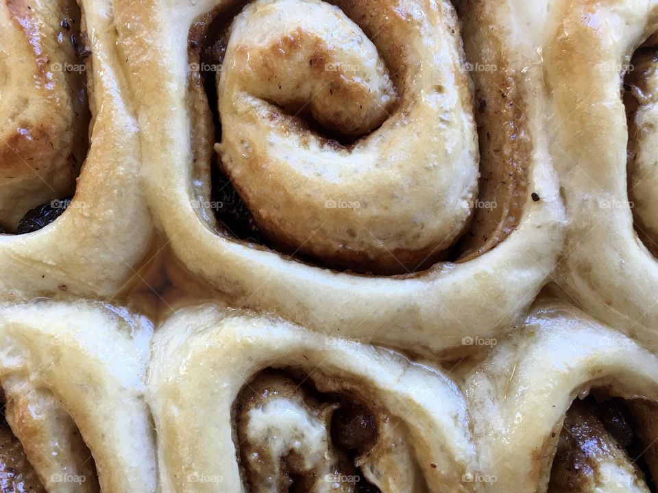 Closeup cinnamon rolls scrolls maple syrup glaze 