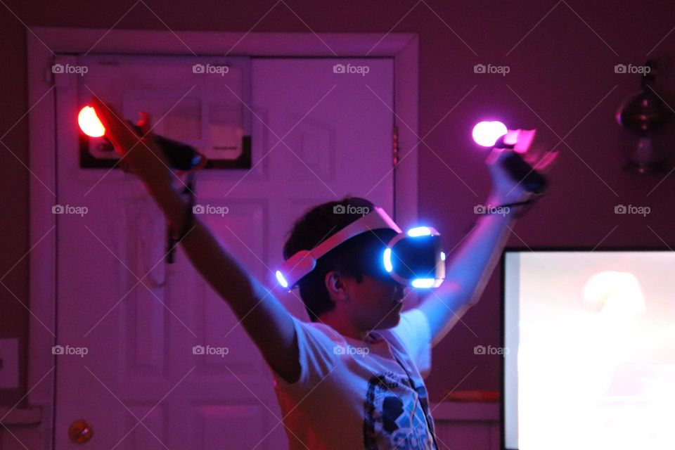 Boy playing virtual game with neon lights glowing