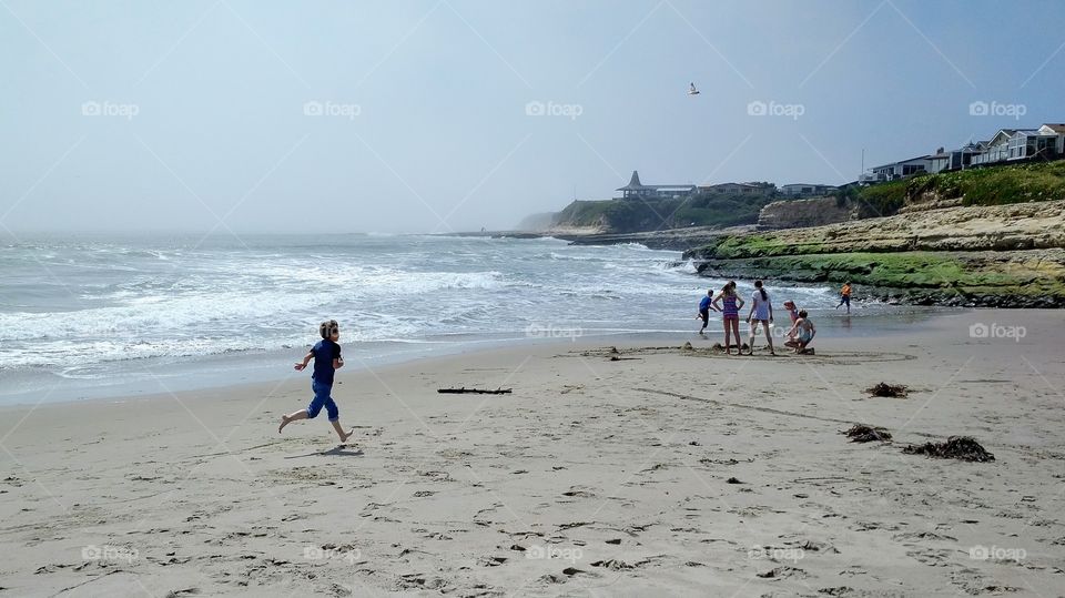 Boy Running and Kids having fun at the beach