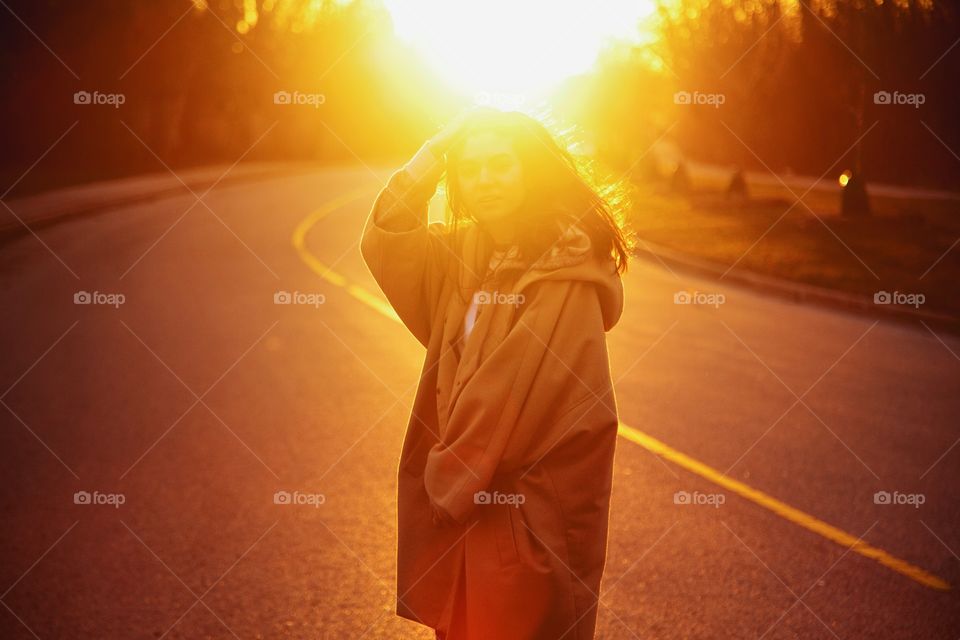 A young woman in bright sun rays