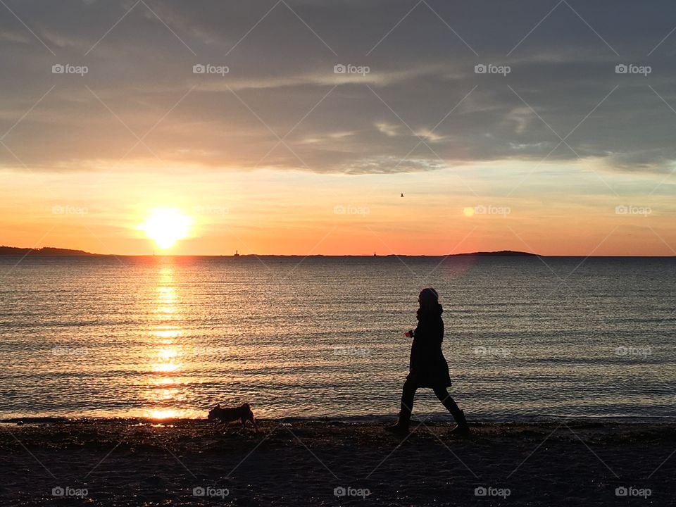 Girl walking her dog on sunrise